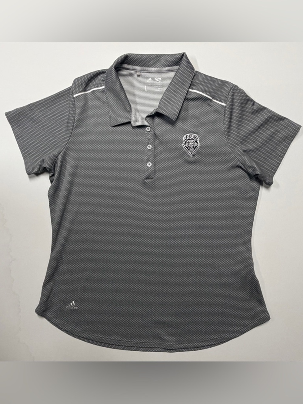 Gray Women’s Polo Top with Subtle Texture and a Lobo’s emblem.